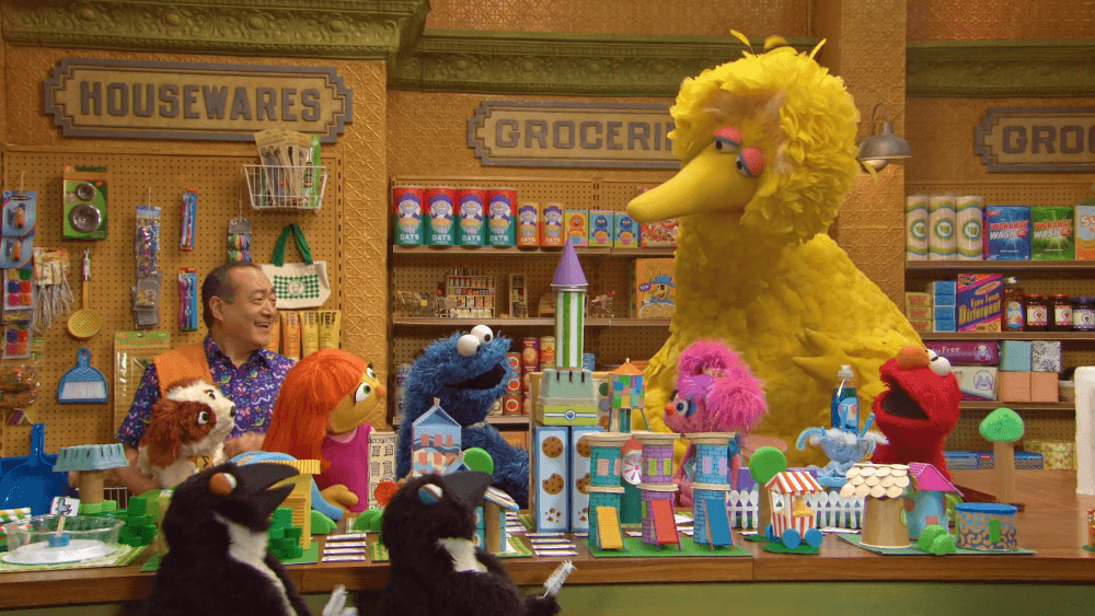 Elmo, Abby, and Julia build a mini city while Grover helps Cookie Monster serve ice cream.